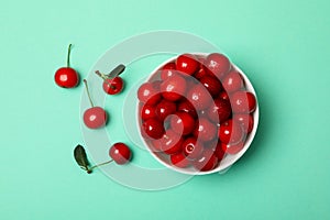 Bowl with fresh red cherry on mint background