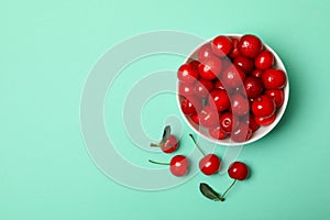 Bowl fresh red cherry on mint background, top view