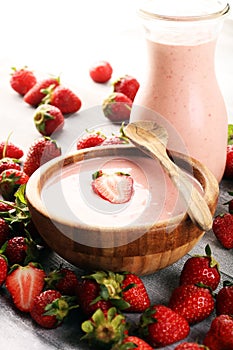 Bowl of fresh strawberry yogurt and fresh strawberries on table. Healthy food and drink concept with juicy fresh fruits and dairy