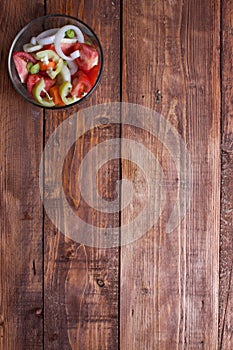 Bowl of fresh vegetable salad on wooden table