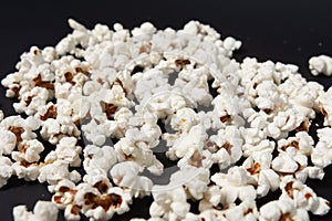 a bowl of freshly cooked popcorn on a black background, popcorn texture