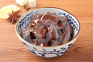 Bowl of fried pork on wooden table in restaurant