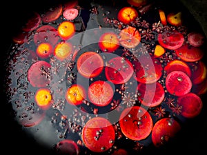 A bowl of fruit with a lot of oranges and a few apples