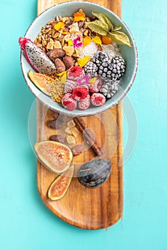 Bowl of fruits and nuts on wooden board