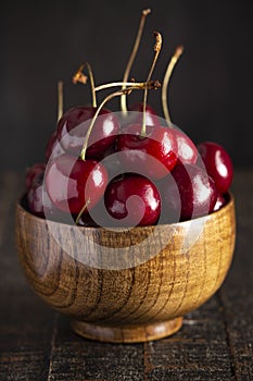 Bowl Full of Dark Red Cherries with Stems on a White Background