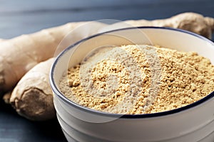 A bowl full of ginger spices on a blue wooden