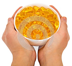 Bowl full of omega 3 capsules in hands