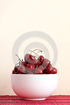 Bowl full of red ripe cherries with copy . space