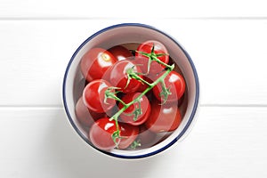 Bowl full of ripe fresh cherry tomatoes on wooden