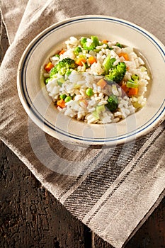 Bowl full of steamed veggies and ristotti risi bisi on napkin