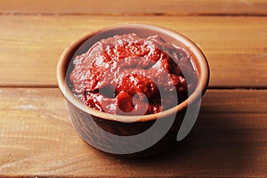 A bowl full of tomato sauce on a wooden