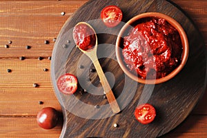 Bowl full of tomato sauce, Wooden spoon full of tomato sauce, spices, seasonings, Sliced ripe cherry tomato slices,