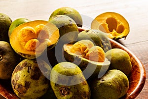 A bowl full of unpeeled pequi fruits. photo