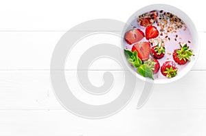 Bowl of granola with strawberries, textspace left, topview