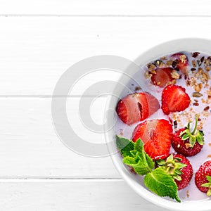 Bowl of granola with strawberries, textspace left, topview photo