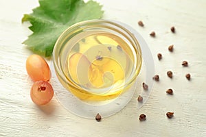 Bowl with grape seed oil on white table