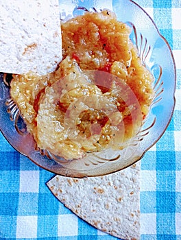 A bowl of Greek Eggplant Salad with a piece of Whole Wheat Tortilla