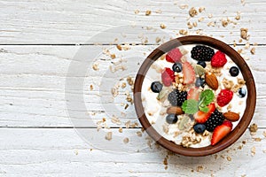 Bowl of greek yogurt with granola, oats, berries and nuts for healthy breakfast photo