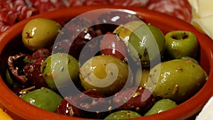 Bowl with green and black olives and herbs