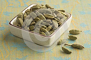 Bowl with green cardamom pods