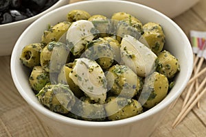 Bowl with green olives, garlic and cilantro