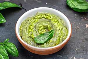 Bowl with green pesto pine nuts, parmesan and garlic. Food recipe background. Close up