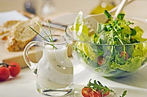 Bowl of greens and salad dressing photo