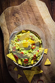 Bowl guacamole corn chips wooden table