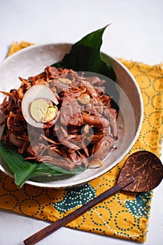 A bowl of gudeg Jogja with egg against white background