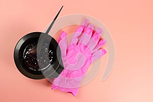 A bowl of hair dye and pink gloves
