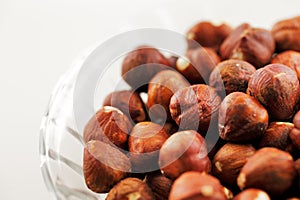 A bowl of hazelnuts on a white background