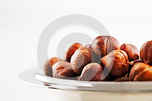 A bowl of hazelnuts on a white background