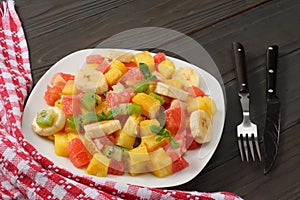 Bowl of healthy citrus fruit salad on dark wooden background