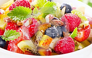 Bowl of healthy fresh fruit salad with honey.