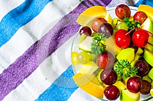 Bowl of healthy fresh fruit salad on pattern of Thai hand made fabric background