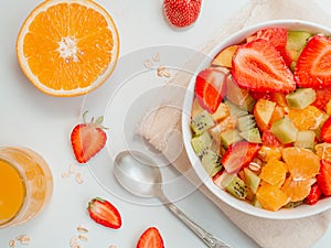 Bowl of healthy fresh fruit salad. Top view. Flat lay summer breakfast concept