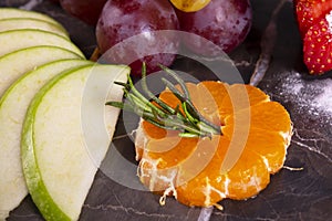 Bowl of healthy fresh fruit salad on wooden background. Top view.