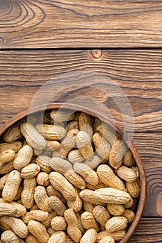 Bowl of healthy natural raw peanuts in shells