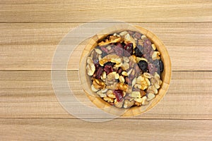 Bowl of healthy trail mix on a wood background