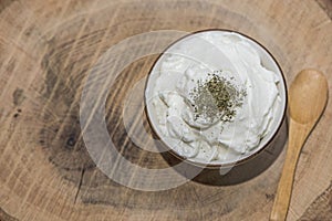 Bowl of healthy yogurth with a wooden spoon, indoor photography, close up