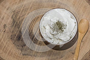 Bowl of healthy yogurth with a wooden spoon, indoor photography, close up photo