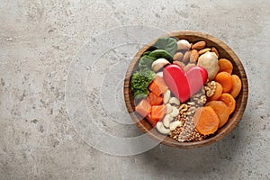 Bowl with heart-healthy products on grey background, top view. Space