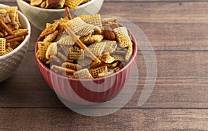 Bowl of Homemade Cereal Nut and Prezel Trail Mix on a Wooden Table