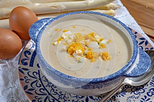 Bowl of homemade cream soup from white asparagus with eggs, spring season, new harvest of Dutch, German white asparagus, cooking