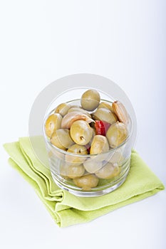 Bowl of homemade olives on a glass, typical spanish tapa, isolated on white background