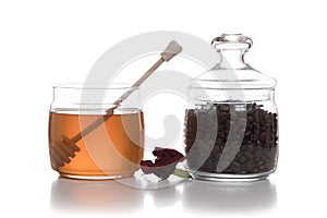 Bowl of honey next to a jar of coffee beans