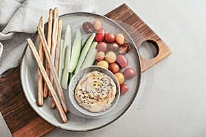 Bowl with hummus, cucumber, cherry tomatoes and grissini breadsticks