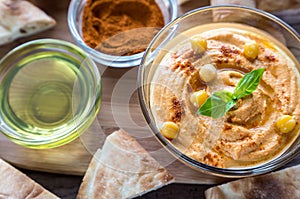 A bowl of hummus with pita slices