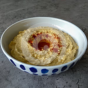 Bowl with hummus topped with olive oil and paprika