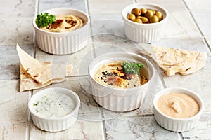 Bowl of hummus, traditional Jewish, Arabian, Middle Eastern food from chick-peas with deeps and with  pita flatbread on ceramic